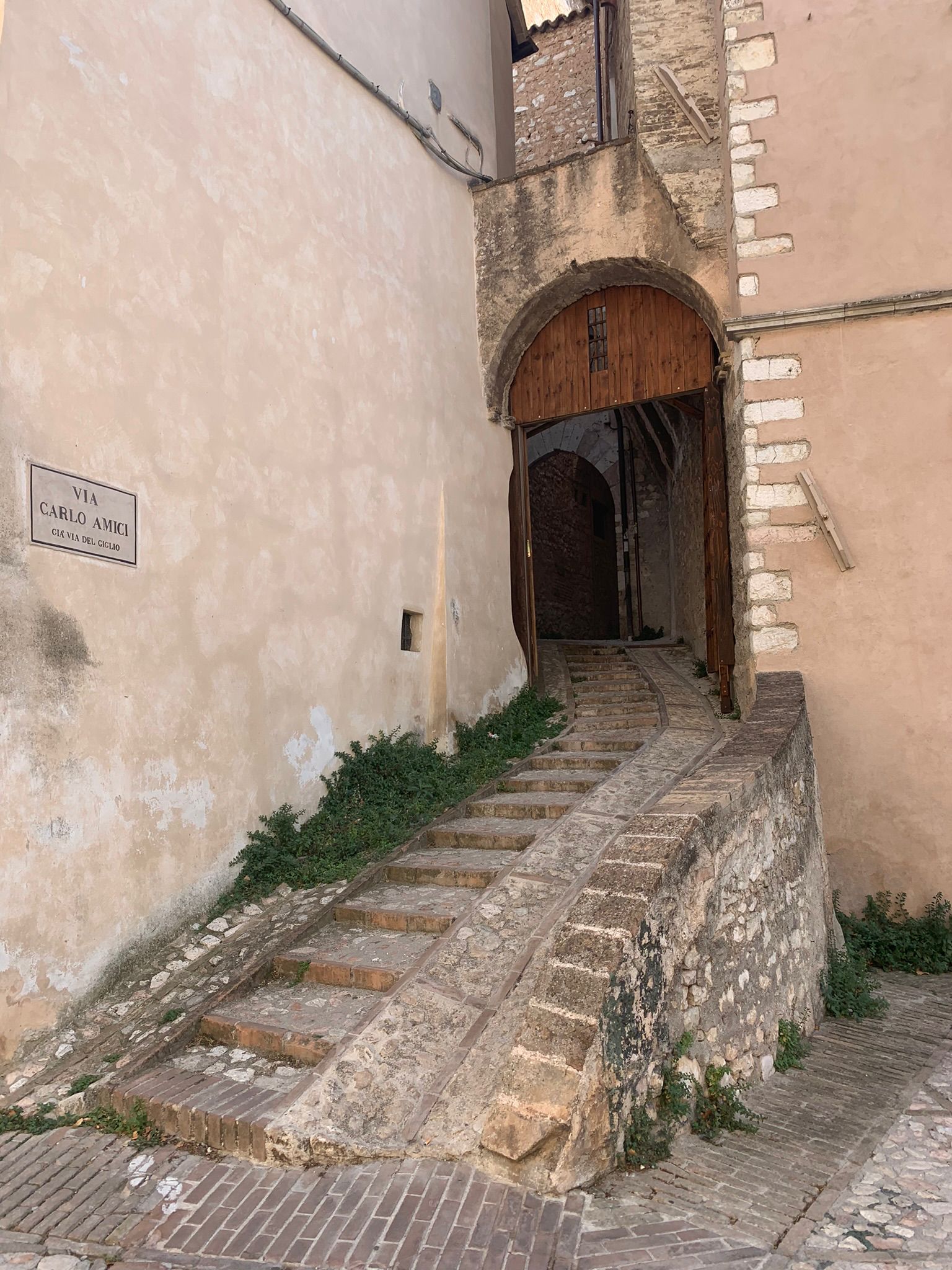 Stairs ascending toward a narrow passage in Trevi’s historic center