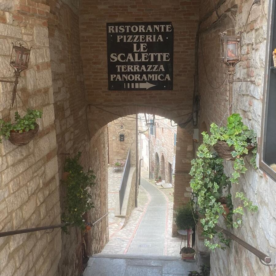 Old stone stairs leading down a charming medieval street in Todi, Umbria