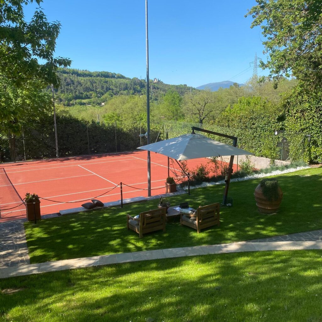Tennis court at Adagio Umbro with panoramic mountain and countryside views in Umbria