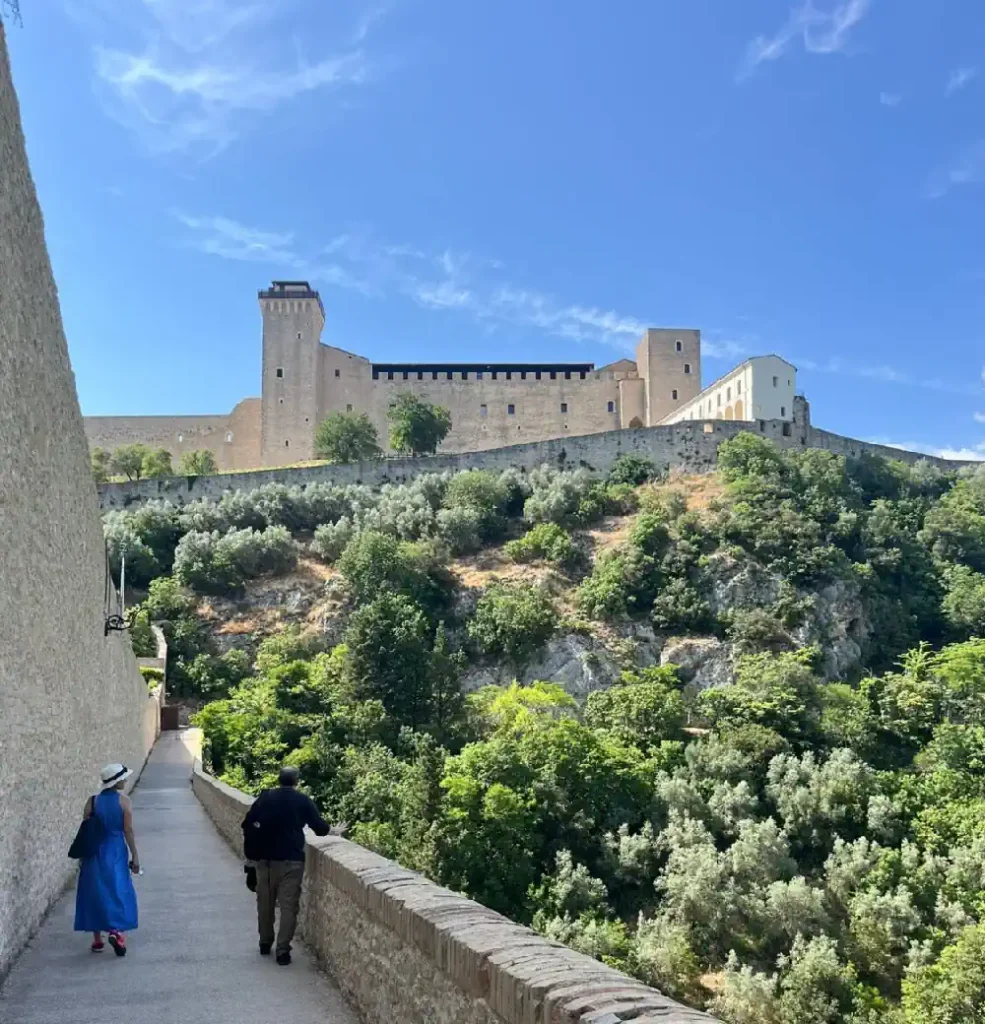 Tourists walking on a historic bridge in Spoleto during a visit to the town
